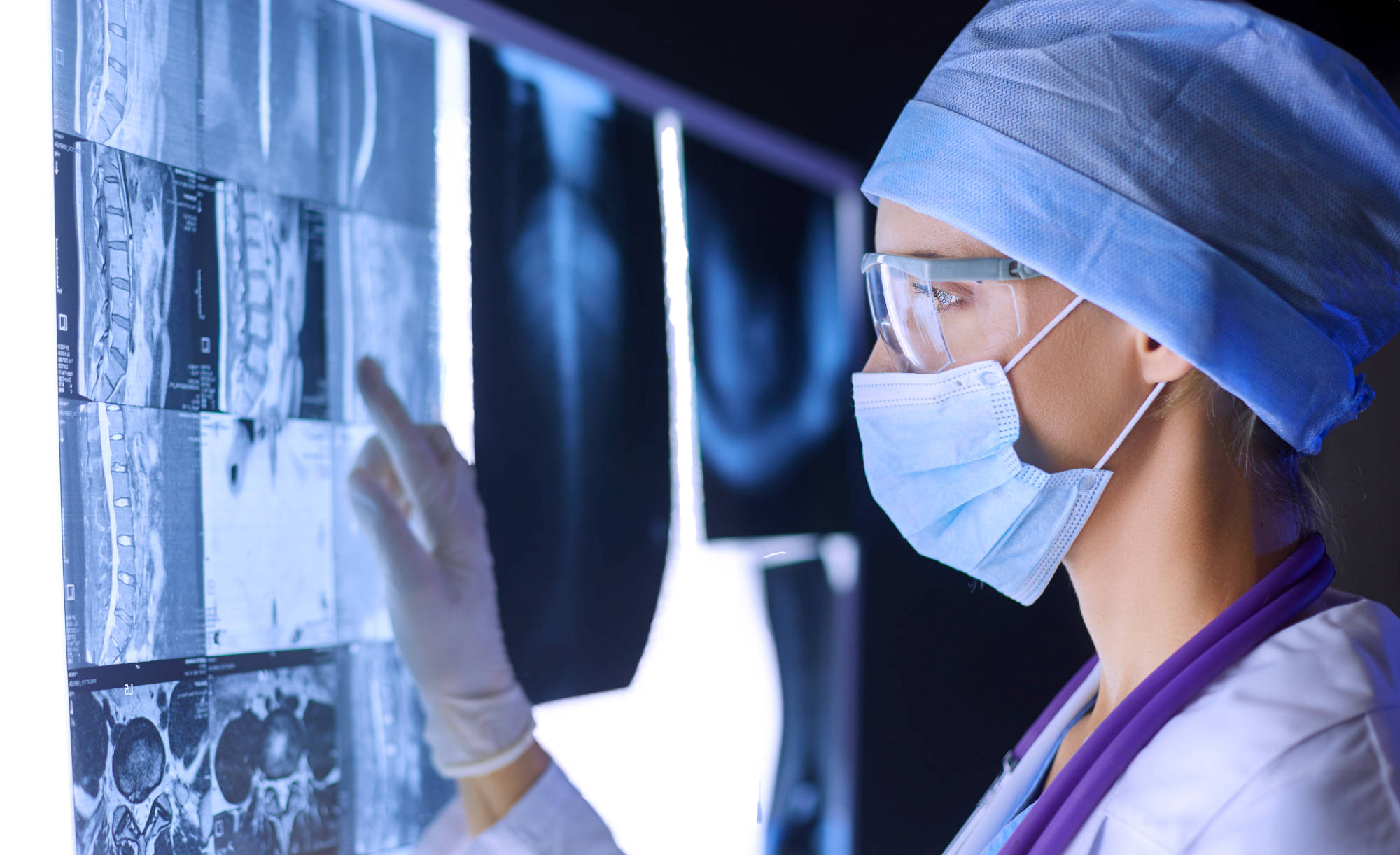 Masked female radiologist reading images